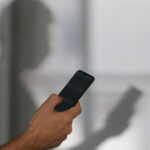 Pessoa segura smartphone durante atendimento digital