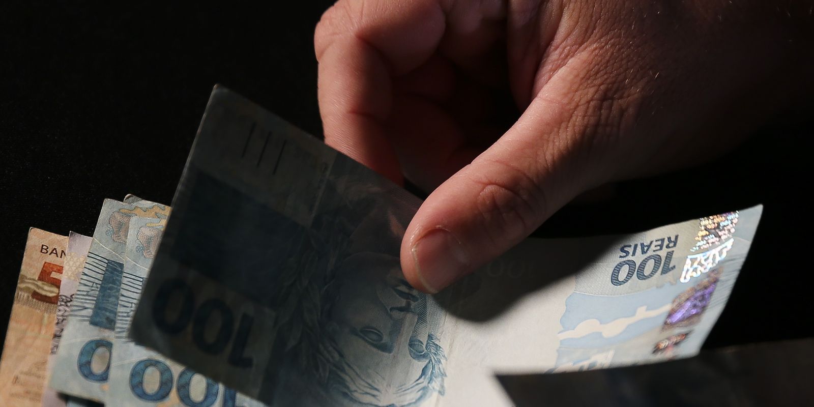 Cédulas e moedas de real usadas para ilustrar o abono salarial