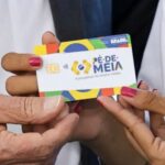 Estudante consulta informações do programa Pé-de-Meia em um telefone celular