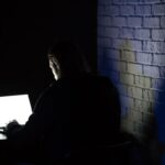 Mulher utiliza computador portátil em ambiente doméstico