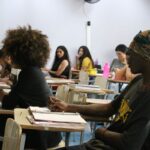 Estudantes caminham em área de universidade pública