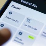 Pessoa usa celular para realizar uma operação financeira pelo Pix