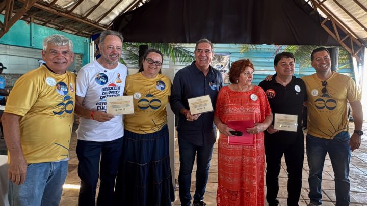 Grupo posa durante celebração de 30 anos da AEPF, com participantes segurando placas de homenagem.